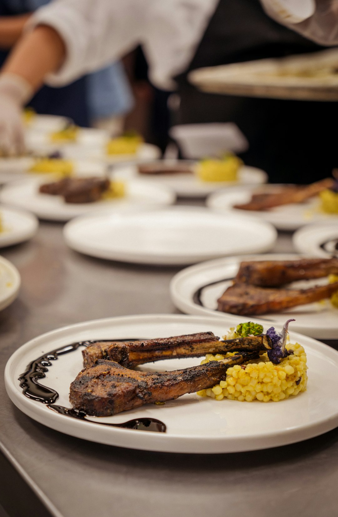 chef-plates-grilled-lamb-chops-with-couscous-and-garnish-jyn7ac7hwhm