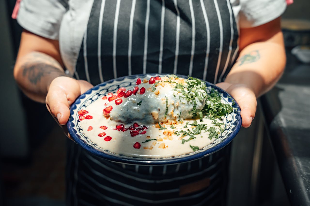 Explore the vibrant flavors of authentic chiles en nogada, a traditional Mexican dish served with creamy sauce.